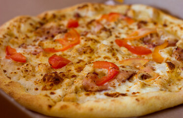 Appetizing pizza with tomatoes and chicken close-up, pizza delivery Italian cuisine
