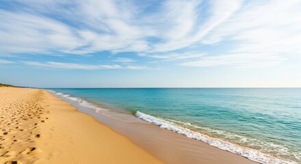 Sandy beach meets turquoise ocean under a partly cloudy sky