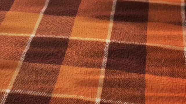 Close-up of a warm and cozy orange and brown plaid blanket Texture Background