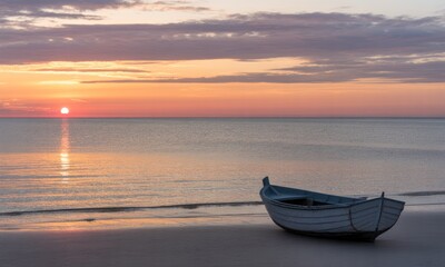 Sunrise over tranquil beach with small boat