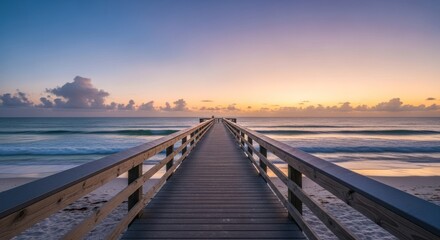 Obraz premium Wooden pier leading to sunrise over ocean