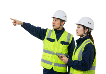 Two diligent construction professionals wearing safety gear collaborate on-site, demonstrating teamwork and precise project planning.