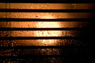 Weather changes. Weather: Sun and rain. Hot days and cool rain. Varied weather conditions outside the window. Meteorology. Sun and rain seen through a window with blinds. Sunset.