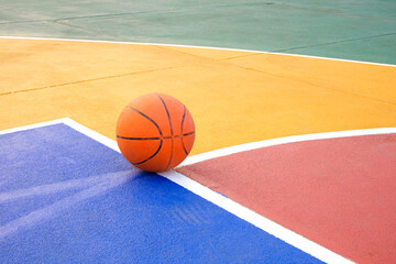 Naklejka premium Basketball court with colorful pattern and basketball on concrete floor surface, Outdoors sport field background