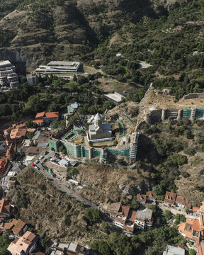 Aerial view of the sun-drenched fortress walls standing firm amidst the urban sprawl and verdant hillsides, Narikala Fortress, Tbilisi, Tbilisi, Georgia.