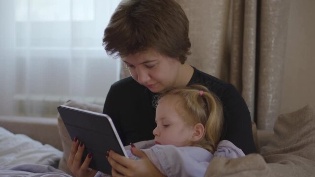 A young mother tenderly cares for her sick little daughter, showcasing authentic emotions of worry, comfort, and unconditional love during challenging parenting moments