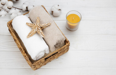 Spa and massage promotional template, cosmetology and relaxation backdrop. Terry rolled up towels on white wooden background. Sea reasort skin care treatment.