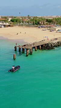 Cinematic drone footage of Santa Maria beach and pier, Sal Island, Cape Verde. Captured at golden hour with turquoise waters, fishing boats and tropical atmosphere in 4K and HD formats.