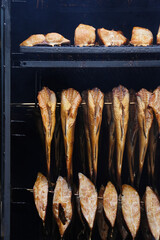 The process of smoking different fish in a smoking chamber in closeup