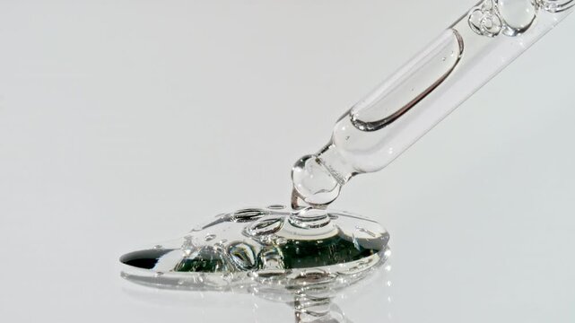 Drops of Essential Oil, Cosmetic Serum Fluid Gel With Molecule Bubbles Spreading From a Glass Pipette. Dermatology science laboratory. Macro Shot of Organic Skin or Body Care Products. High quality 4k