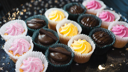 Beautiful chocolate and assorted cupcakes on an elegant plate, perfect for parties or family gatherings. Soft lighting and shallow depth of field.