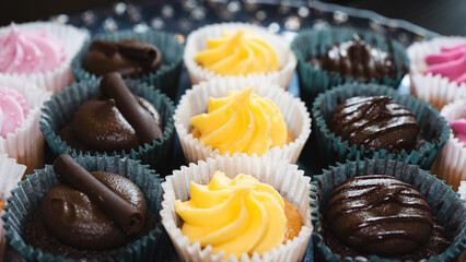 Beautiful chocolate and assorted cupcakes on an elegant plate, perfect for parties or family gatherings. Soft lighting and shallow depth of field.