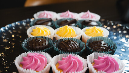Beautiful chocolate and assorted cupcakes on an elegant plate, perfect for parties or family gatherings. Soft lighting and shallow depth of field.