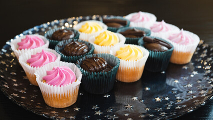 Beautiful chocolate and assorted cupcakes on an elegant plate, perfect for parties or family gatherings. Soft lighting and shallow depth of field.