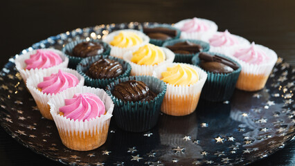 Beautiful chocolate and assorted cupcakes on an elegant plate, perfect for parties or family gatherings. Soft lighting and shallow depth of field.