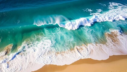 Aerial view of powerful turquoise waves crashing on a sandy beach.
