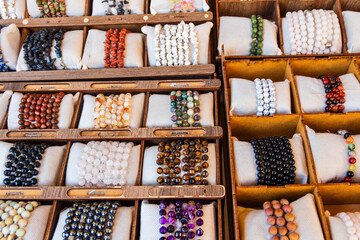 Colorful bracelets made of beads and precious stones, traditional handicrafts, displayed in a market.