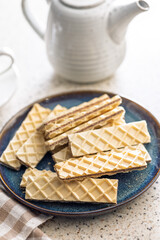 Sweet crispy wafers on plate on kitchen table.