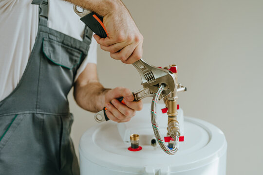 Man fixing water heater using wrench