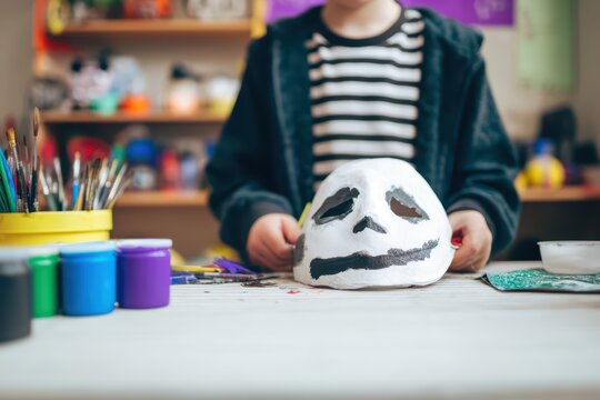 Creative Child Painting Skull Mask in Art Classroom with Colorful Supplies and Joyful Atmosphere