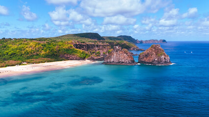 Visão aérea impressionante do Morro Dois Irmãos em Fernando de Noronha, cercado por mar azul cristalino e natureza exuberante, um dos cenários mais icônicos do Brasil © RNL Fotografia