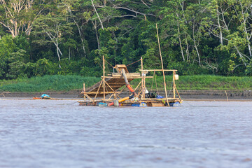 Illegal mining in Amazonian rivers like the Madre de Dios in Peru, gold dredges extracting gold...