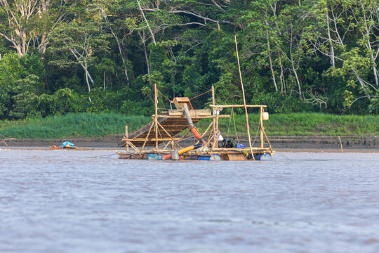 Illegal mining in Amazonian rivers like the Madre de Dios in Peru, gold dredges extracting gold from the riverbed