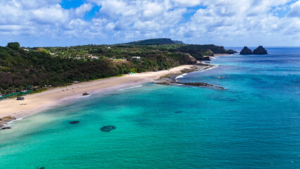 Praia do Boldró em Fernando de Noronha ilumina o horizonte, criando uma atmosfera mágica com mar calmo e natureza exuberante.