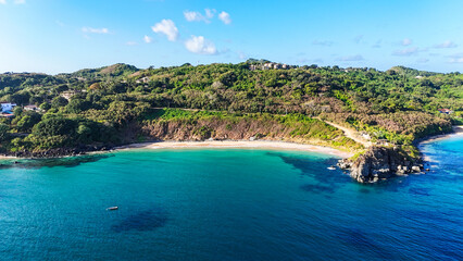 Fototapeta premium Praia do Meio vista do alto, em Fernando de Noronha, com mar azul e areia clara. Cena paradisíaca de litoral tropical, ideal para fotografia aérea, turismo ecológico e apreciação da natureza