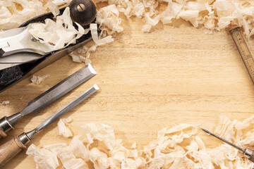 Carpentry or woodworking background with copy space. Old carpentry tools and wood shavings on a...