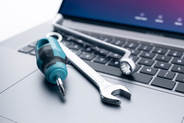 Computer fixing, service or maintenance concept background. Working tools on modern laptop computer