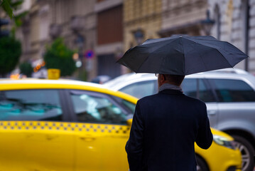 Person with umbrella against moving cars