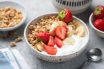 Healthy fitness diet meal: Greek Yogurt bowl with strawberry, banana and granola
