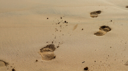 Pegadas na areia dourada de uma praia em Noronha, Brasil. Detalhe simples que transmite tranquilidade, contato com a natureza e o clima tropical do arquipélago