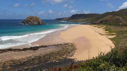 Praia do Leão em Fernando de Noronha com mar azul intenso, areia dourada e falésias, uma das paisagens mais selvagens e bonitas do arquipélago
