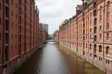 Naklejka premium A classic view of a canal in the historic Speicherstadt warehouse district with its red-brick buildings in Hamburg, Germany.