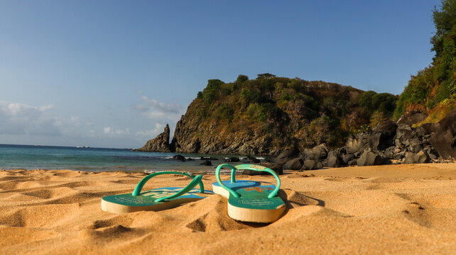 Chinelos Havaianas coloridos sobre a areia em uma praia paradis&iacute;aca de Fernando de Noronha, capturando o clima tropical e relaxante do arquip&eacute;lago. Fernando de Noronha PE em 10 agosto 25
