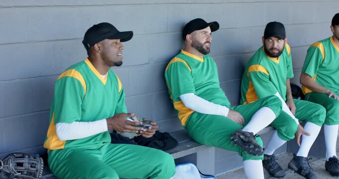 Spotting play on field male player pointing snapping selfie with teammates in dugout, for memory