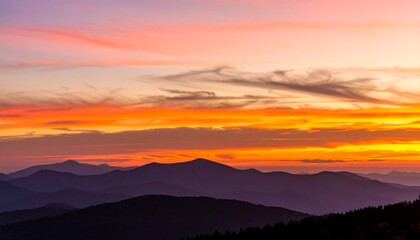 Obraz premium A breathtaking panorama of layered mountains, bathed in the fiery hues of a vibrant sunset.