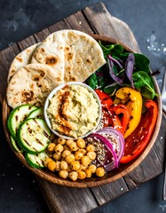 Healthy meal bowl with hummus, vegetables and flatbread