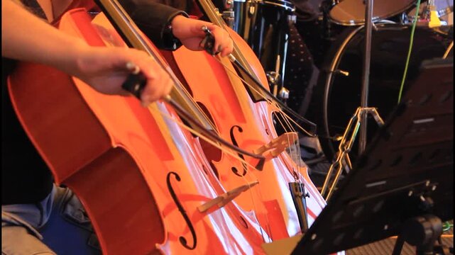 MUSICOS TOCANDO VIOLONCHELOS EN CONCIERTO MUSICAL