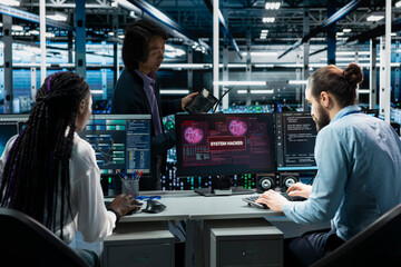 Server farm engineers seeing hacking warning, working to secure systems from cyberattack accessing confidential data. Team of data center IT experts fighting virus during security breach