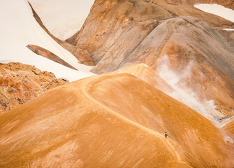 Icelandic highland landscape at Kerlingarfjöll mountains with orange soil, hot springs and snow