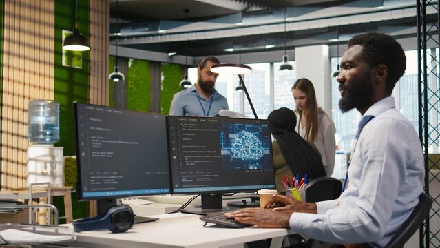 System administrator in office using PC, automating repetitive tasks with AI scripts. IT specialist using artificial intelligence technology to speed up feature implementation, camera A
