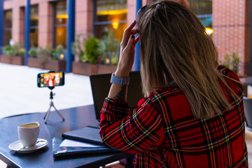 Fototapeta premium Influencer recording video blog outdoors, using smartphone and tripod