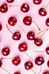 Close up of red raw fresh sweet cherries on pink background. Macro view emphasizing texture, juiciness, and freshness for food designs, health eating, wallpaper, backdrop