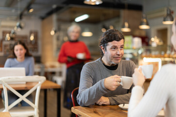 Meeting in cafe of two lovers. Man talks to girl over a cup of coffee