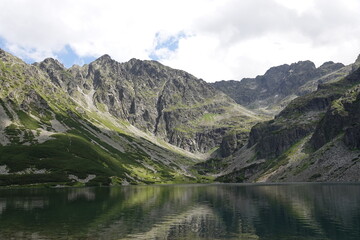 Zbiornik wodny w górach z widocznym zielonym zboczem góry © tomo81