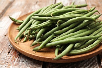 Fresh pea pods on color wooden table, closeup