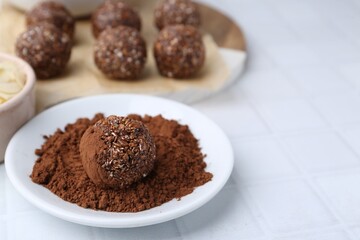 Making homemade candies. Chocolate balls and ingredients on white tiled table, closeup. Space for text